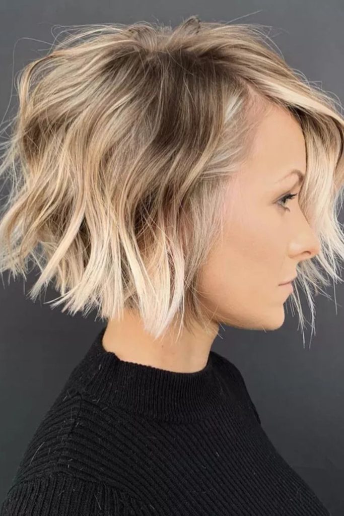 Textured beauty—this wavy blonde bob with a dark backdrop and ribbed black sweater creates a bold yet cozy contrast.
#wavybob #texturedhaircut #blondebobstyle #modernlook #cozyvibes