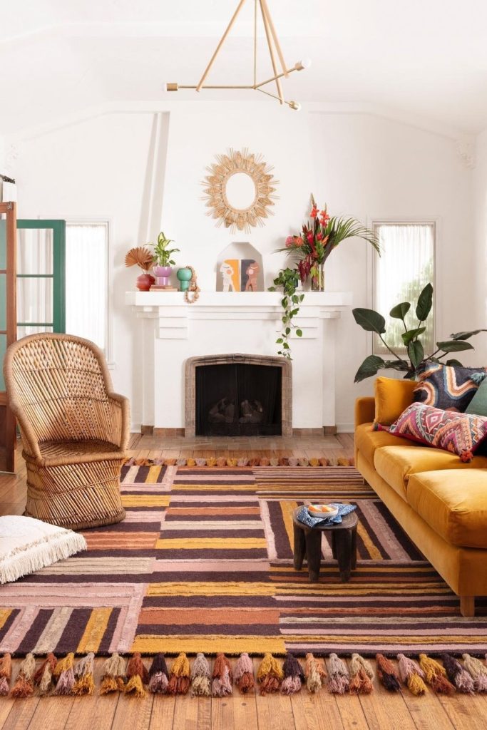 Bright and cheerful, this mustard-toned living room combines a playful rug, wicker chair, and bold wall art with natural greenery for an eclectic, cozy feel.
#MustardSofa #CozyEclectic #ColorfulHome #GreenPlants #WarmDecor