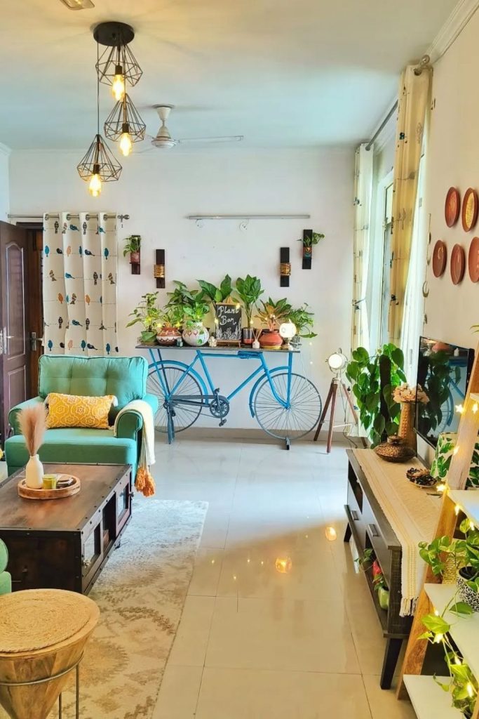 This quirky, cozy space uses a blue bicycle as a plant stand, paired with a green armchair and hanging lights. Bright, creative, and inviting—just how a living room should feel.
#CreativeLivingRoom #GreenArmchair #IndoorPlants #CozyVibes #WhimsicalDecor